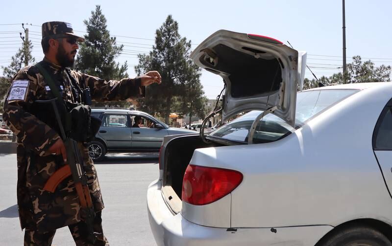 Taliban forces check a car in Kabul. EPA