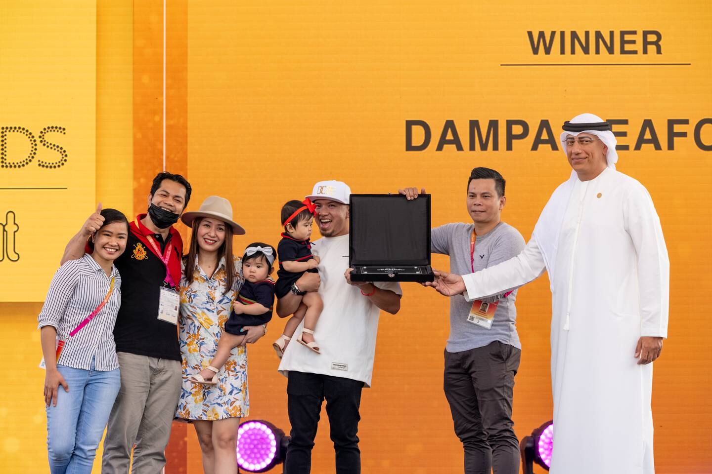 Ahmed Al Khatib, right, chief development and delivery officer at Expo 2020 Dubai, presents an award to the Dampa Seafood Grill team during the Expo Eats Awards ceremony. Photo: Expo 2020 Dubai