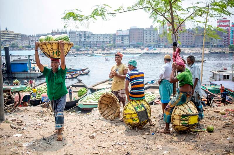 Bangladeshi labourers unload watermelons from a boat at the Buriganga River in Dhaka. The fruit is in season and is filling the city markets. EPA