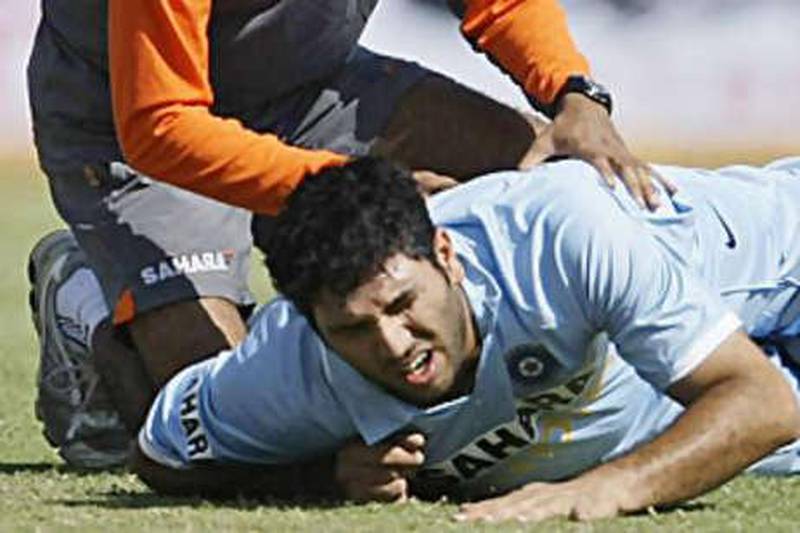 Yuvraj Singh winces in pain with back spasms in the first one day international while physio Nitin Patel attends to him in Rajkot on Friday. Yuvraj scored 138 runs in just 78 balls to take that first game away from England.