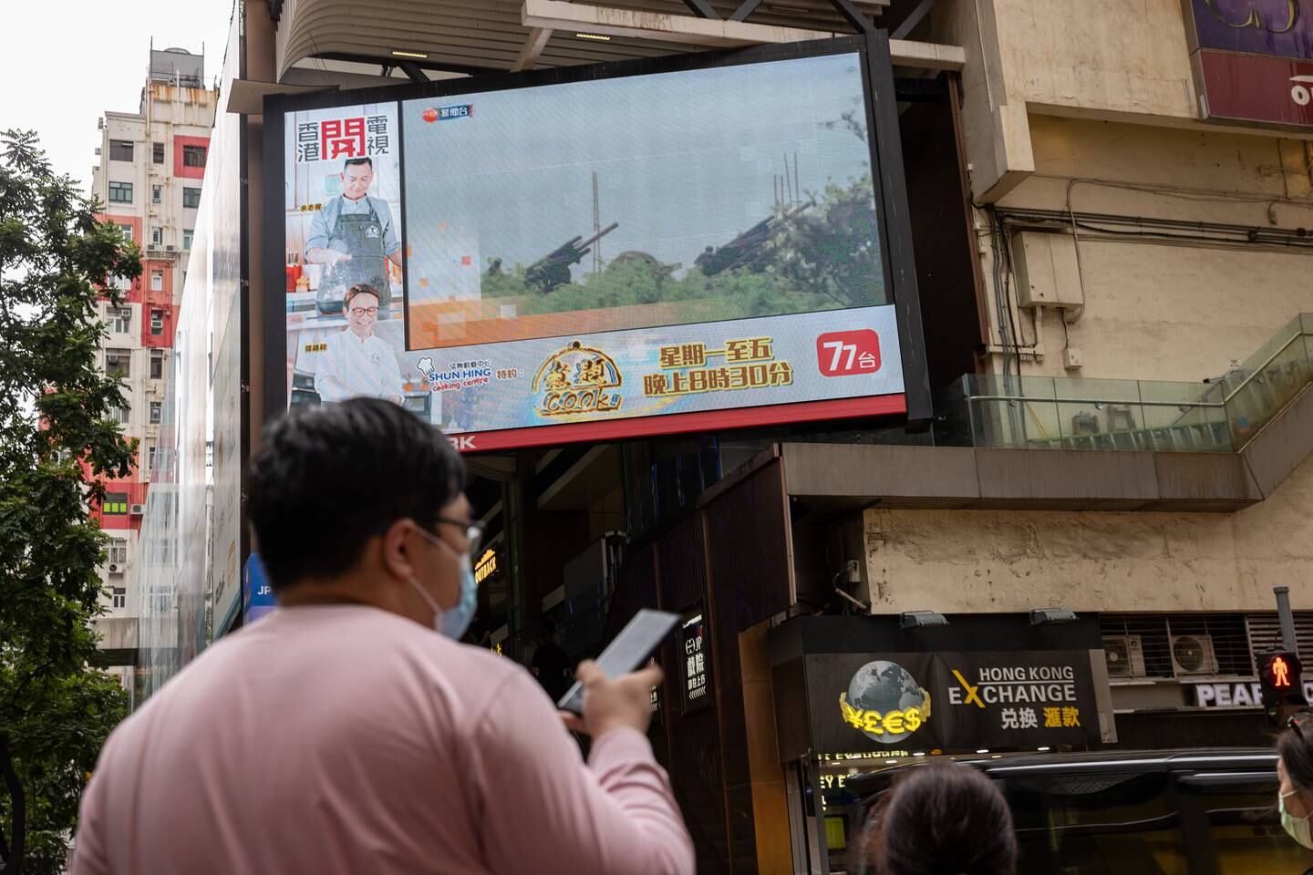 A screen displays news broadcasting Taiwanese army artillery pieces during a live-fire drill, in Hong Kong, on August 9. EPA 