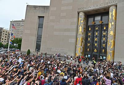 Protesters take a knee and raise their fists during a "Black Lives Matter" demonstration in front of the Brooklyn Library and Grand Army Plaza on June 5, 2020 in Brooklyn, New York, amid ongoing protests over the death in police custody of George Floyd. - The United States has seen more than a week of nationwide protests over the death in police custody of George Floyd, captured in a shocking video showing white officer Derek Chauvin kneeling on Floyd's neck for nearly nine minutes as he pleaded for his life. (Photo by Angela Weiss / AFP)