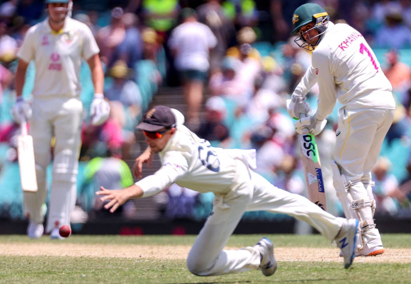 England’s captain Joe Root (C) dives as Australia batsman Usman Khawaja makes another century. AFP