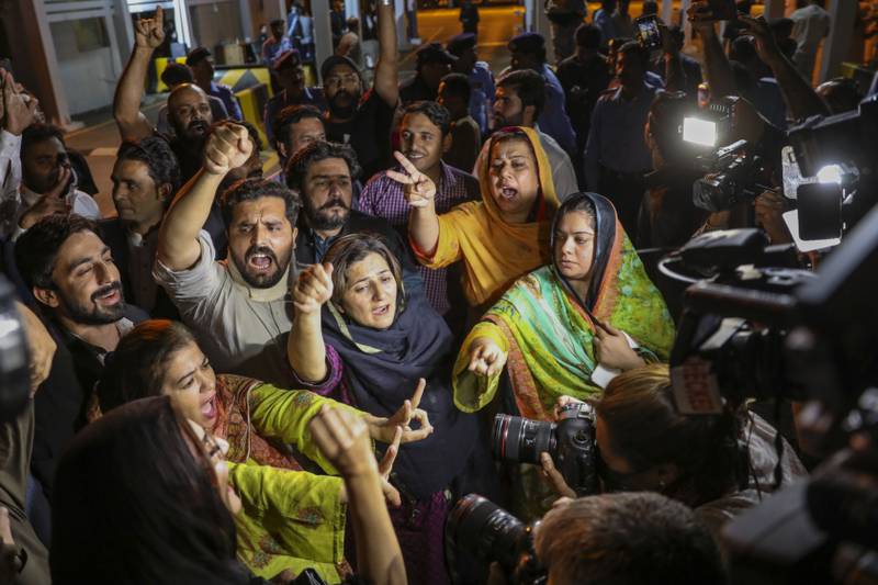 Politicians and supporters of Mr Khan chant slogans outside the National Assembly in Islamabad. Bloomberg