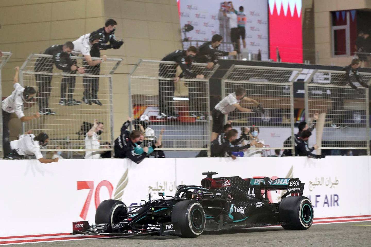 FILE - In this Sunday, Nov. 29, 2020 file photo Mercedes driver Lewis Hamilton of Britain is congratulated by his pit crew after wining the Formula One race in Bahrain International Circuit in Sakhir, Bahrain. World champion Lewis Hamilton tested positive for COVID-19 and will miss the Sakhir Grand Prix this weekend, his Mercedes-AMG Petronas F1 Team said Tuesday Dec. 1, 2020. (Tolga Bozoglu, Pool via AP, File)
