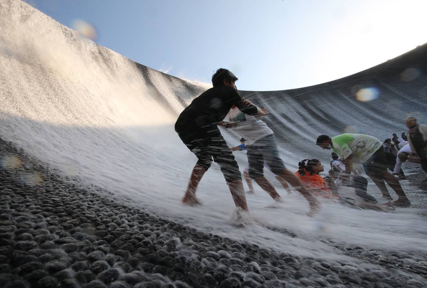 People enjoy their time at the Surreal waterfall at Expo 2020 Dubai. Photo: EPA 