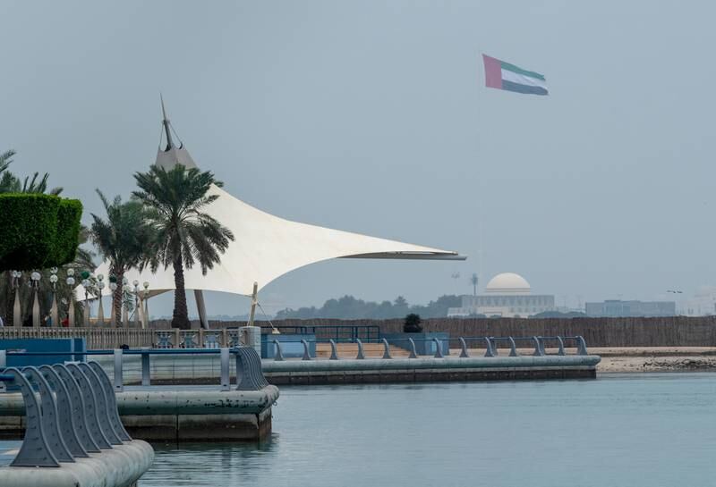 A brisk breeze has the UAE flag fluttering on the Corniche in Abu Dhabi. Victor Besa / The National