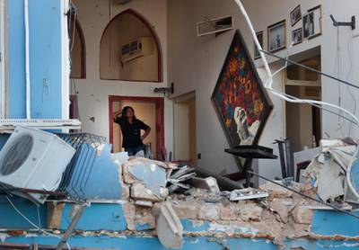 A woman stands inside a damaged restaurant. AP Photo