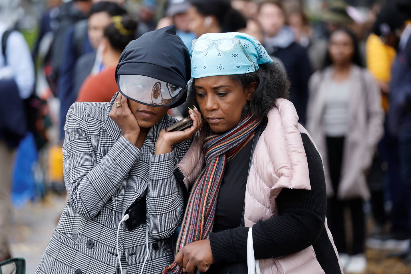 People listen to Supreme Court arguments over their phone as they queue hoping to be seated inside to watch arguments in the affirmative action case in Washington on Monday.  Reuters