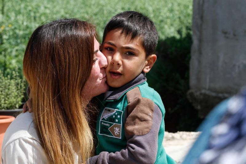 Ms Naameh, 33, kisses her son at home in the southern Lebanese village of Zawtar. AFP