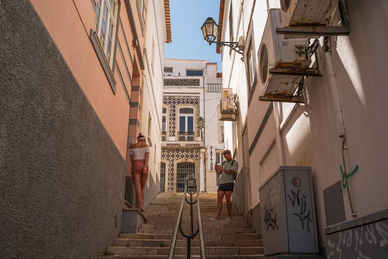 Tourists stop on a side street to take a photograph in Lagos, Portugal. Bloomberg