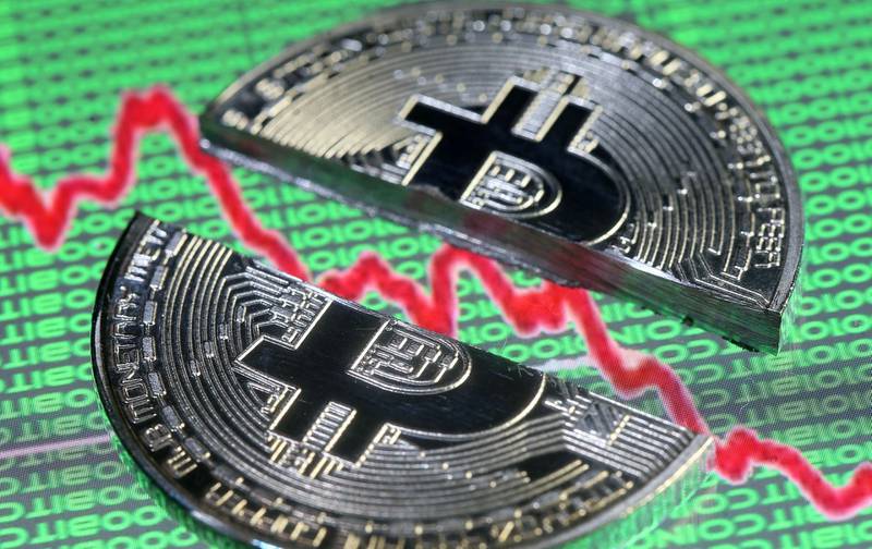 FILE PHOTO: Broken representation of the Bitcoin virtual currency, placed on a monitor that displays stock graph and binary codes, are seen in this illustration picture, December 21, 2017. REUTERS/Dado Ruvic/Illustration/File Photo