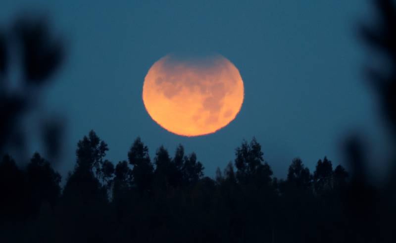 The Moon, with its upper hemisphere partially eclipsed, over Monte Pedroso, in Santiago de Compostela, north-west Spain, early on the morning of November 19, 2021. EPA