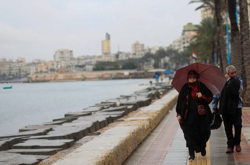 People walk during rainy weather in Alexandria. Egypt’s transportation sector is the second largest contributor to the country’s greenhouse emissions after energy. Reuters