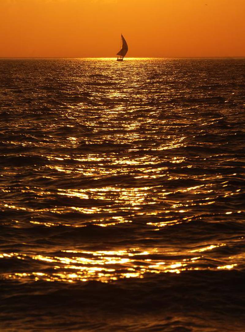 The sun sets as a sailboat cruises along Lake Michigan off the shores of St Joseph, Michigan.Don Campbell / The Herald-Palladium via AP
