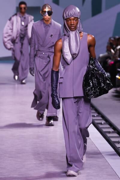 Models filed past, wearing long jackets with crisp lapels, clutching shiny bags, their looks topped off with curved bucket hats and baseball caps. EPA

