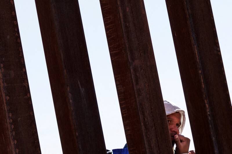 A migrant seeking asylum in the US waits in Rio Bravo at the border fence between Mexico and America. Reuters