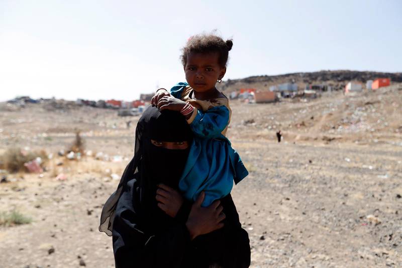 A displaced Yemeni woman carries her child at a camp for Internally Displaced Persons (IDPs) on the outskirts of Sana'a, Yemen. EPA