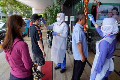 Nurses check the temperatures of visitors as part of the coronavirus screening procedure at a hospital in Kuala Lumpur. AP Photo