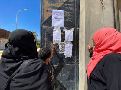 Locals view a list of the missing following the floods in Derna. Reuters