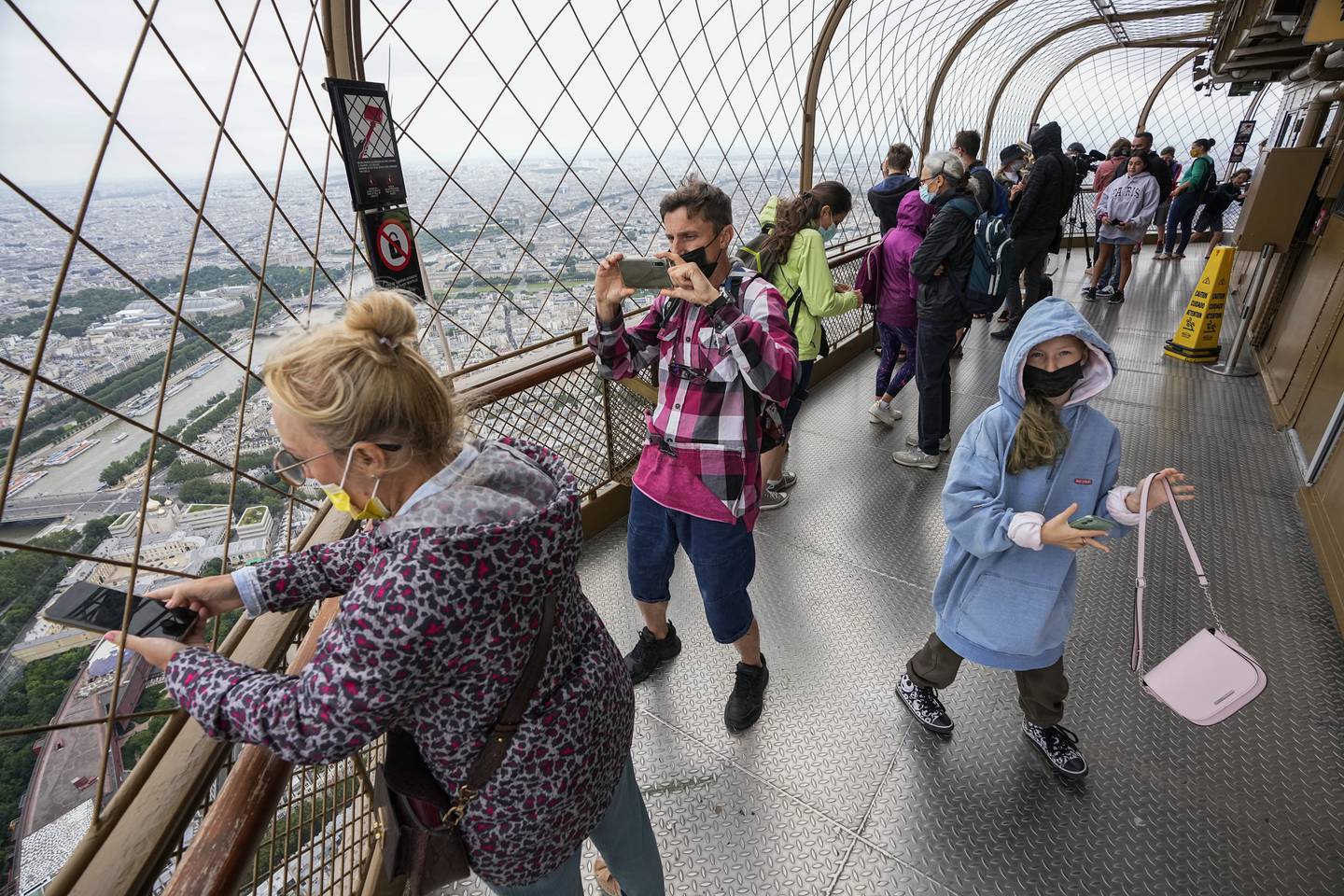Visitors enjoy the view from top of the Eiffel Tower in Paris.  The European Union has recommended reimposing travel restrictions on travellers from the US and five other countries. AP Photo