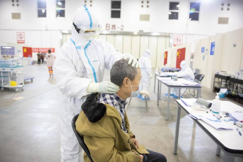 A medical staff in protective suit massages a patient at Wuhan Fang Cang makeshift hospital in Wuhan, Hubei Province, China.  EPA
