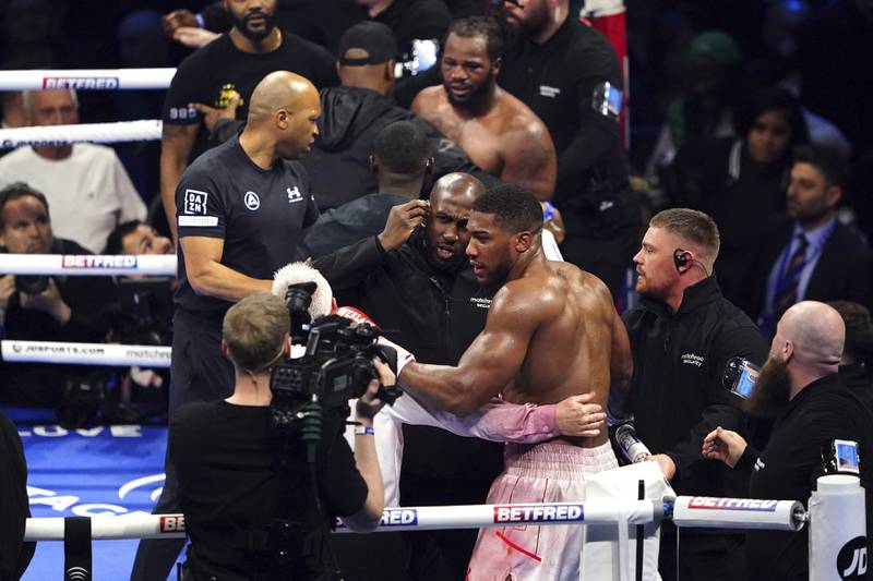 Anthony Joshua is pulled away by referee Marcus McDonnell after clashing with Jermaine Franklin and a member of Franklin's coaching staff after a heavyweight boxing match at The O2. AP