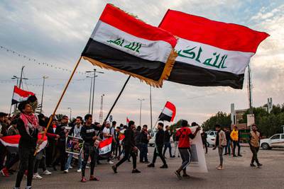 Protesters march with national flags during an anti-government demonstration, also calling for freedom of the press, in the southern Iraqi city of Basra.   AFP