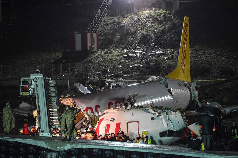 Turkish soldiers stand guard as rescuers work to extract passengers from the crash of a Pegasus Airlines Boeing 737 airplane, after it skidded off the runway upon landing at Sabiha Gokcen airport in Istanbul on February 5, 2020.  The plane carrying 171 passengers from the Aegean port city of Izmir split into three after landing in rough weather. Officials said no-one had lost their lives in the accident, but dozens of people were injured. / AFP / Ozan KOSE
