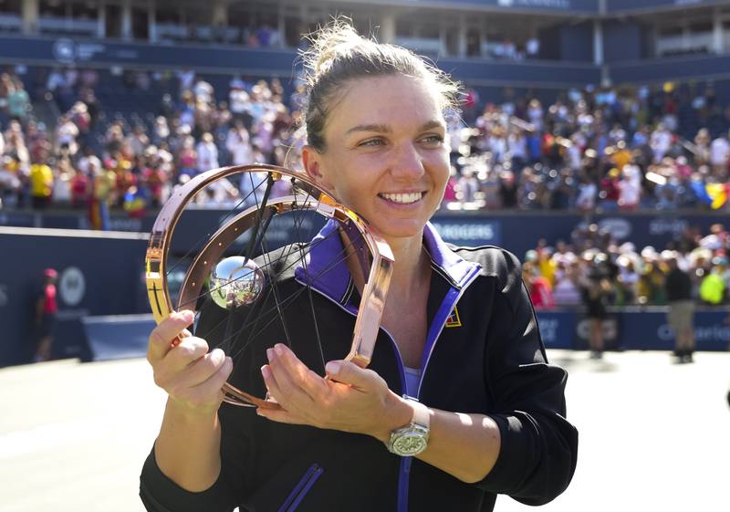 Simona Halep, of Romania, holds the trophy after defeating Beatriz Haddad Maia, of Brazil, to win in the finals of the National Bank Open tennis tournament in Toronto. AP