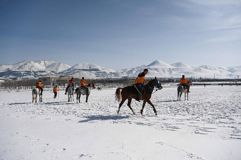 Players warm up before their jereed match against a wintry background in Erzurum, Turkey.  AFP