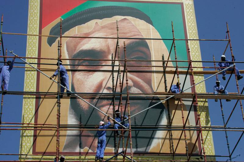 Asian workers clean and repaint a giant portrait of the United Arab Emirates' late leader, Sheikh Zayed bin Sultan al-Nahayan, in preparation for marking the second anniversary of his death, 02 November 2006 in the Gulf emirate of Dubai. Sheikh Zayed, the founding father of the UAE, died 02 November 2004 after more than 30 years at the helm of his oil-rich country. AFP PHOTO/KARIM SAHIB / AFP PHOTO / KARIM SAHIB