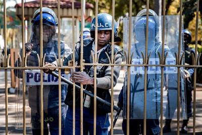 Zimbabwean anti riot police officers close the gate of the Rainbow Towers where the election's results were announced. AFP
