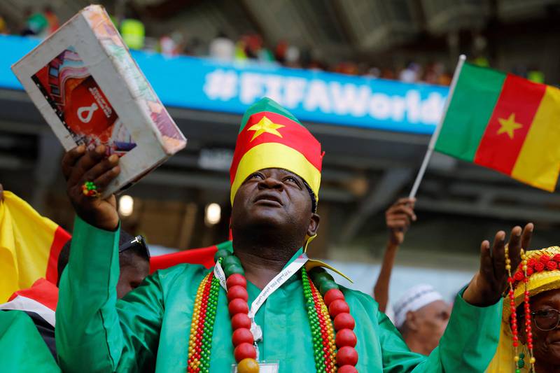 One Cameroon fan puts his faith in God while cheering on his team. AFP