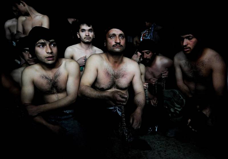 Men hold chains as they wait to take part in ritual self-flagellation to celebrate Ashura, at a mosque in Kabul. January 15, 2008. Shah Marai / AFP