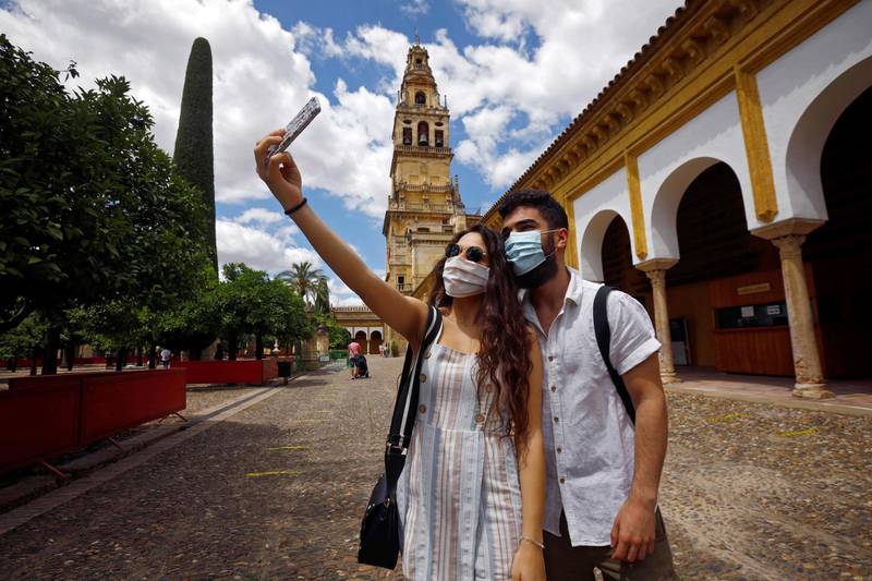 epa08482545 Two people takes a selfie at The Orange Trees courtyard as they visit Cathedral-Mosque of Cordoba, Andalusia, Spain, 13 June 2020. Cordoba is in the last phase of coronavirus lockdown exit process.  EPA/Salas