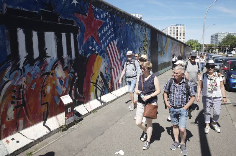 Visitors in front of the East Side Gallery in Berlin. In Germany, 24 per cent of travellers believe ecological sustainability is an important criterion when booking a holiday. AP