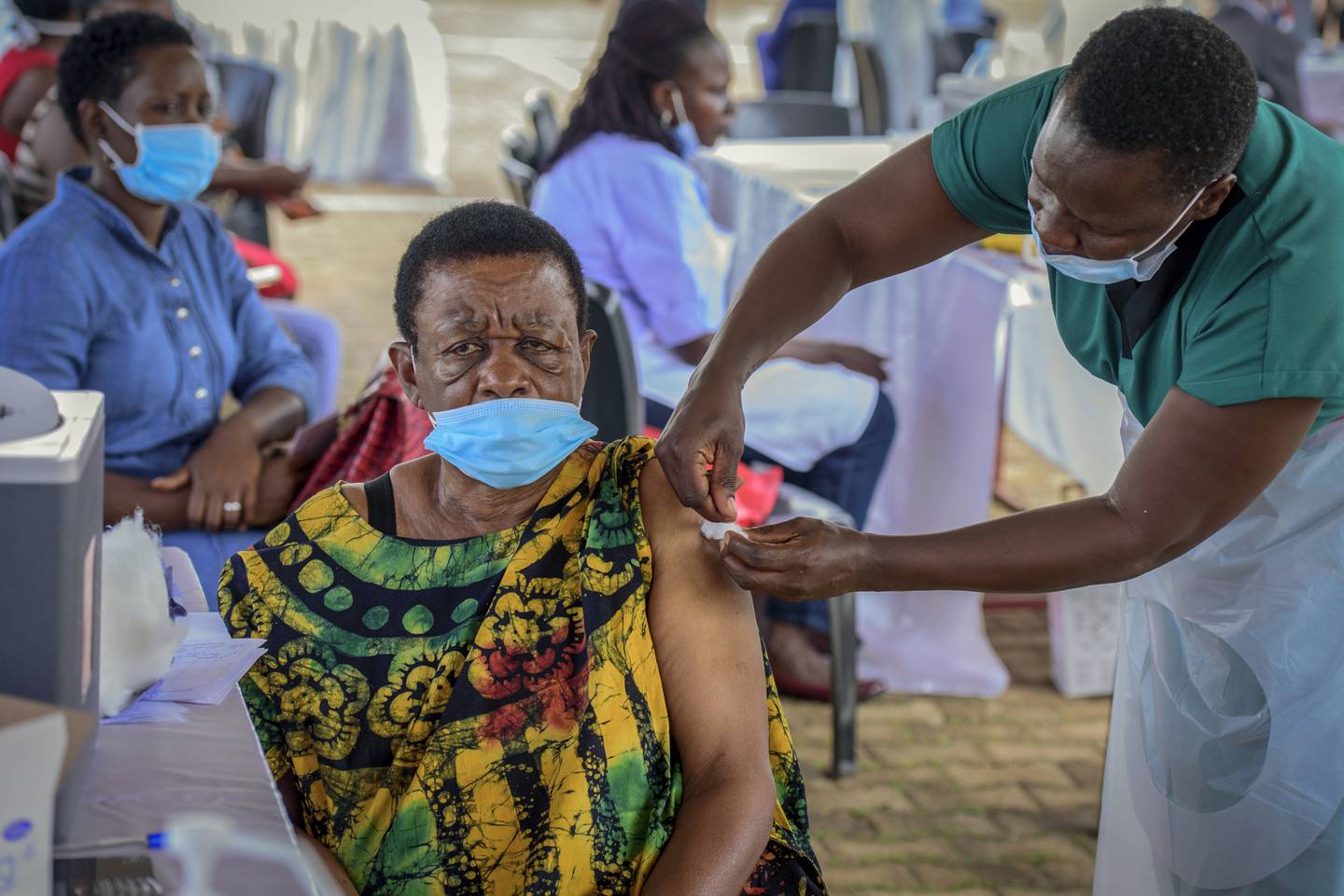 A woman receives a coronavirus vaccine at the Kololo airstrip in Kampala, Uganda. AP