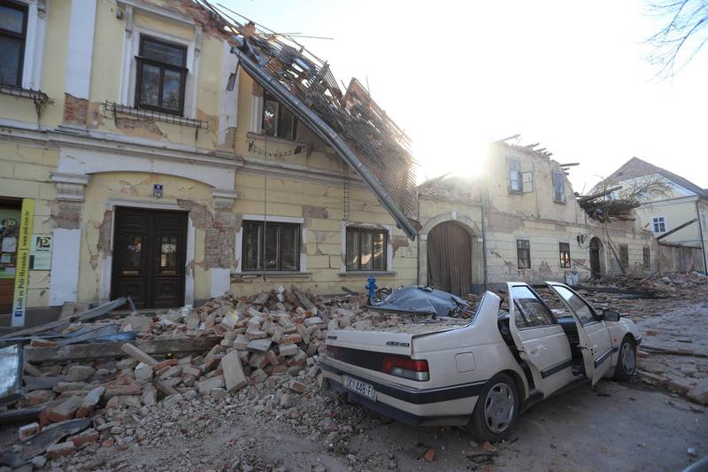 Destroyed houses and a car are seen on a street after an earthquake in Petrinja, Croatia.  REUTERS