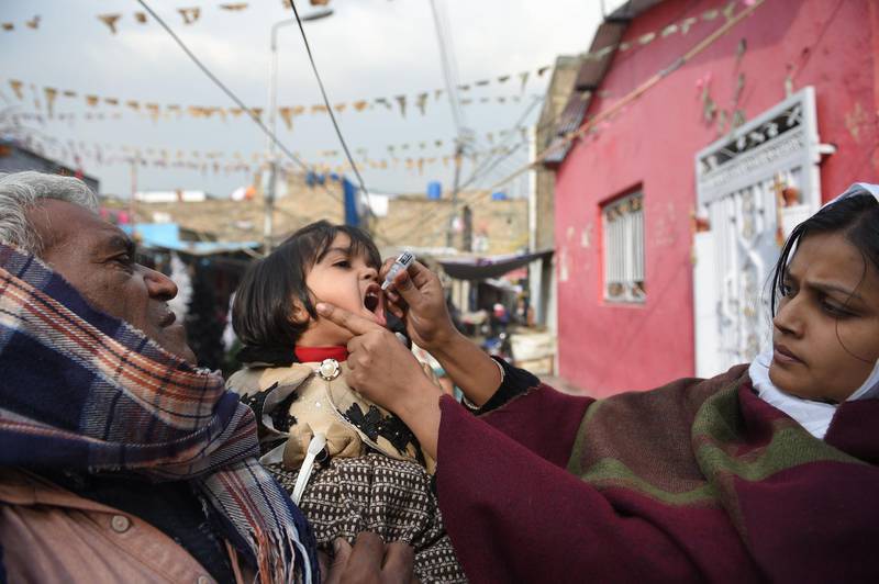 A Pakistani Christian health worker administers polio vaccine drops to a child during a polio vaccination campaign in a Christian colony in Islamabad on December 12, 2018. The United States on Tuesday added Pakistan to its blacklist of countries that violate religious freedom, ramping up pressure over the uneasy ally's treatment of minorities. / AFP / FAROOQ NAEEM
