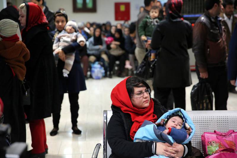An Iranian woman holds her child at the Mofid Children's Hospital in Tehran. The government is encouraging more Iranians to have children as the birth rate continues to slide. Ebrahim Noroozi / AP Photo 