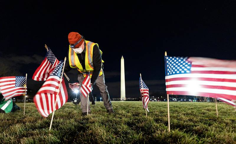 A crew member places flags as part of the public art display 'Field of Flags'. EPA