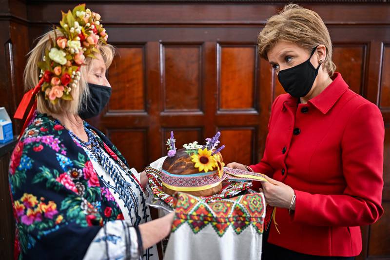 Scotland's First Minister Nicola Sturgeon, right, at the Edinburgh Ukrainian Club, speaks to members of the Ukrainian community about their concerns and views some of the donations.