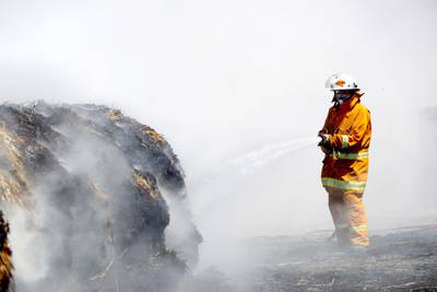 A Country Fire Service (CFS) member puts out a fire which reached hay bales on a property at Mount Torrens in the Adelaide Hills. Reuters