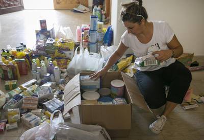 Sandra Takac, volunteer coordinator at the Serbian embassy, sorts through donations on Friday prior to dispatch. Mona Al Marzooqi / The National 