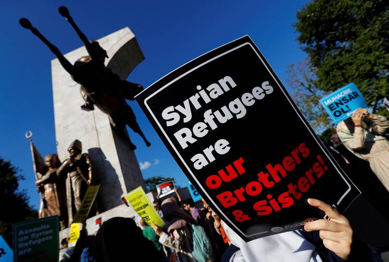 FILE PHOTO: Demonstrators hold placards in support of Syrian refugees during a protest against Turkish government's recent refugee policies in Istanbul, Turkey, July 27, 2019. REUTERS/Murad Sezer/File Photo