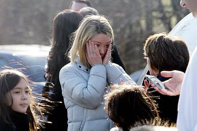 A woman weeps as she arrives to pick up her children. AP