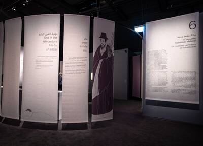 A snaking arrangement of paper banners segments the exhibition and provides historical context.