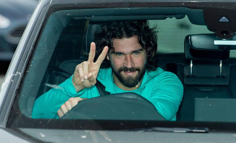 Liverpool goalkeeper Alisson Becker gives a V-sign as he arrives for a training session to the Melwood training facility in Liverpool. EPA