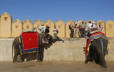 Foreign tourists get off elephants after riding them into the Amber fort near the city in Jaipur. Andrew Caballero-Reynolds / AFP